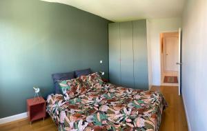 ein Schlafzimmer mit einem Bett mit einer farbenfrohen Tagesdecke in der Unterkunft Appartement vue mer à 100m des plages, classé 4* in Biarritz