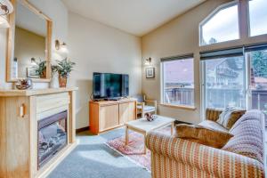 sala de estar con chimenea y TV en Icicle Village Resort 507 & 508: Alpine Reflections en Leavenworth