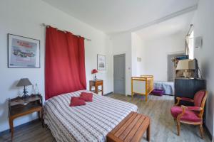 1 dormitorio con cama y cortina roja en Petit Gîte de Villecomte, en Sainte-Solange