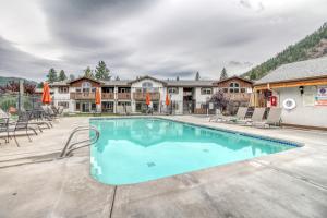 una piscina con sillas y sombrillas en Icicle Village Resort 507 & 508: Alpine Reflections en Leavenworth