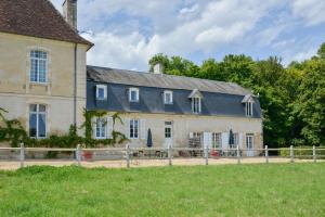 una casa vieja con una valla delante de ella en Petit Gîte de Villecomte, en Sainte-Solange