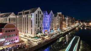 miasto świeci nocą rzeką w obiekcie Apartamenty Sun & Snow Deo Plaza Granaria w Gdańsku
