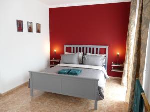 a bedroom with a white bed with a red wall at Casa Fialli 