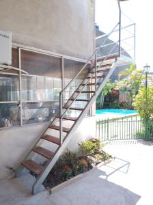 a metal staircase next to a building with a pool at Departamento en 1•piso. centro. pileta in Formosa