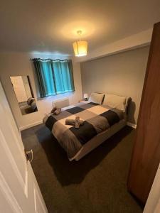 a bedroom with a large bed and a mirror at Cozy 2 Bed Flat in Cricklewood in London