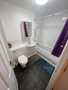 a bathroom with a toilet and a tub and a sink at Cozy 2 Bed Flat in Cricklewood in London
