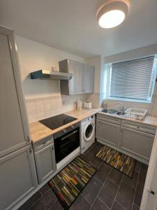 een keuken met een wastafel en een fornuis top oven bij Cozy 2 Bed Flat in Cricklewood in Londen
