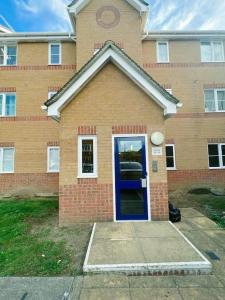 een bakstenen gebouw met een blauwe deur voor de deur bij Cozy 2 Bed Flat in Cricklewood in Londen