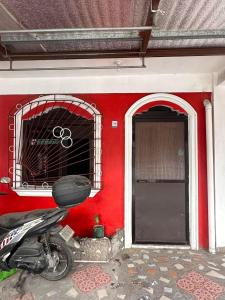 una motocicleta estacionada frente a un edificio rojo en Saracal Aparthomes, en Mati