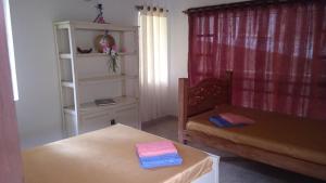 um quarto com uma cadeira, uma mesa e uma prateleira em Hotel Casa la Gregorienne em La Vega