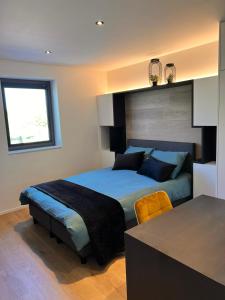 a bedroom with a bed and a table in it at Inova Guesthouse in Hasselt