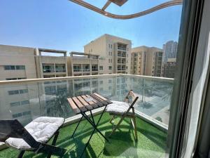 a balcony with a table and chairs on a building at Lux BnB 1BD The Greens Parking Pool Gym in Dubai