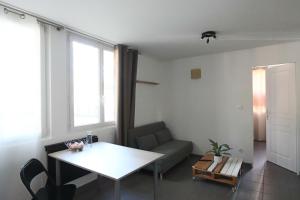 - un salon avec une table et un canapé dans l'établissement Appartement Les Trois Renards-Tassin, à Tassin-la-Demi-Lune