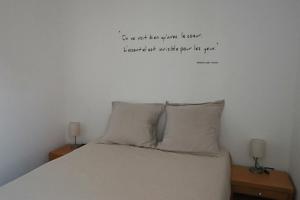 a bedroom with a bed with a quote on the wall at Appartement Les Trois Renards-Tassin in Tassin-la-Demi-Lune