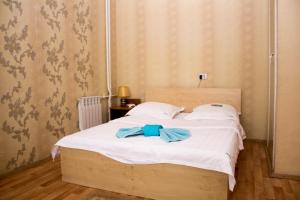 a bedroom with a bed with a blue bow on it at Валенсия in Petropavlovsk