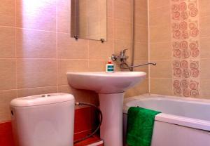 uma casa de banho com um lavatório, um WC e uma banheira em Валенсия em Petropavl