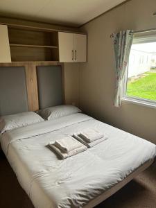 a bed in a small room with two towels on it at 87 Lancaster Crescent in Tattershall