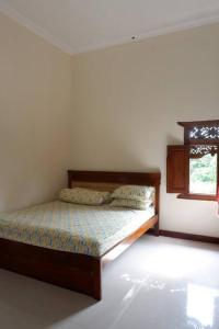 sypialnia z łóżkiem w pokoju z oknem w obiekcie Omah Pinaringan w mieście Surakarta