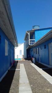 a blue building with a walkway in front of it at Residencial Água Azul in Capão da Canoa