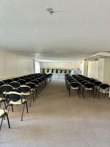 Una habitación grande con un montón de sillas. en Mandai Apart en Cabo Frío