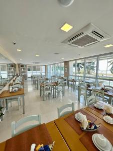 a restaurant with wooden tables and chairs and windows at Mandai Apart in Cabo Frio