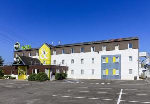 ein Hotel mit Parkplatz davor in der Unterkunft B&B HOTEL Dijon Nord Zénith in Dijon