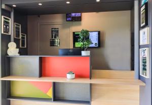 a lobby with a colorful counter with a potted plant at B&B HOTEL Dijon Nord Zénith in Dijon