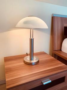 a lamp on a wooden table in a room at Dachgeschoss-Ferienwohnung in Sonthofen