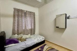 a room with a bed with a stuffed animal on it at K & J Homestay — Seremban Jaya 7 in Seremban