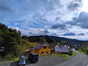 a yellow house on the side of a road at Penzion Sally in Albrechtice v Jizerských horách