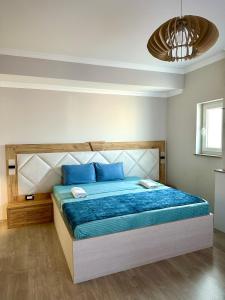 a bedroom with a bed with blue sheets and blue pillows at Hotel Borea in Peje