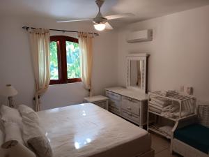 a bedroom with a bed and a dresser and a mirror at Newly Renovated Seaside Oasis at Bonita Village in Las Terrenas