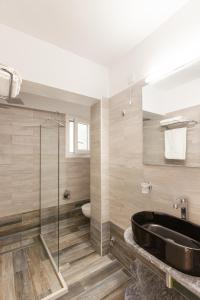 a bathroom with a sink and a glass shower at Marina Apartments in Kokkari