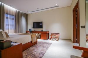 a hotel room with a bed and a television at Vivian Park El Raeid Hotel in Riyadh