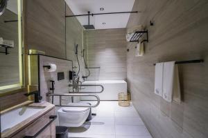 a bathroom with two toilets and a sink and a tub at Vivian Park El Raeid Hotel in Riyadh
