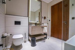 a bathroom with a toilet and a sink and a mirror at Vivian Park El Raeid Hotel in Riyadh