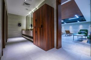 a hallway with a wooden door and a table and chairs at Vivian Park El Raeid Hotel in Riyadh