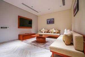 a living room with a couch and a tv at Vivian Park El Raeid Hotel in Riyadh