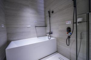 a shower with a white tub in a bathroom at Vivian Park El Raeid Hotel in Riyadh