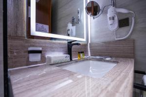 a bathroom with a sink and a mirror at Vivian Park El Raeid Hotel in Riyadh