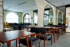 a dining room with tables and chairs and windows at Vivian Park El Raeid Hotel in Riyadh