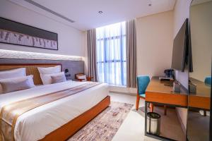 a bedroom with a bed and a desk and a television at Vivian Park El Raeid Hotel in Riyadh