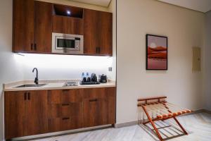 a kitchen with a sink and a microwave at Vivian Park El Raeid Hotel in Riyadh