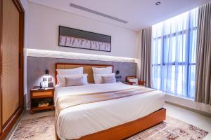 a bedroom with a large bed and a large window at Vivian Park El Raeid Hotel in Riyadh