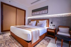 a bedroom with a large bed and a chair at Vivian Park El Raeid Hotel in Riyadh