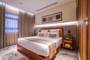 a bedroom with a large bed and a large window at Vivian Park El Raeid Hotel in Riyadh