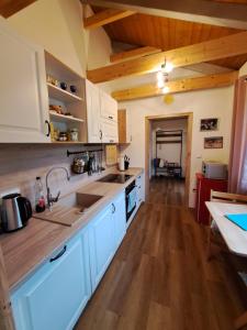 een keuken met witte kasten en een houten vloer bij Útulný apartmán 
