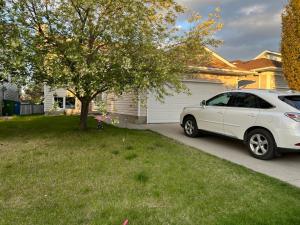 a white car parked in the driveway of a house at citadel cozy quilt private bedroom in Calgary