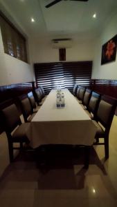 une salle à manger avec une grande table et des chaises dans l'établissement Queens Tourist Home, à Badagara