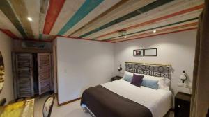 a bedroom with a bed with a painted ceiling at Rincón Escondido B&B in Puerto Iguazú